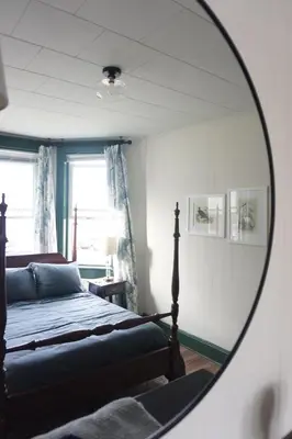 a bedroom with a bed and a mirror at Charming Victorian Home In Historic District in Newburgh