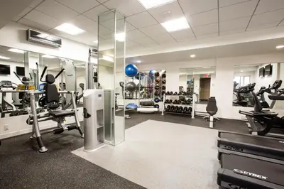 a gym with treadmills and machines in a room at Midtown E Studio w Great light Gym NYC-139 in New York
