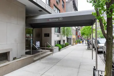 a building with a sign on the side of a sidewalk at Midtown E Studio w Great light Gym NYC-139 in New York