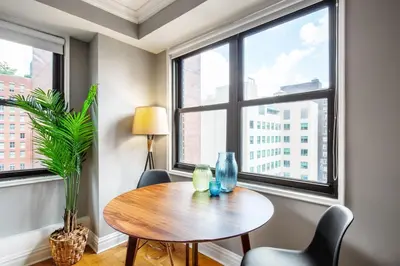 a table and chairs in a room with windows at Midtown E Studio w Great light Gym NYC-139 in New York