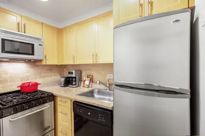 a kitchen with a white refrigerator and a sink at Midtown E Studio w Great light Gym NYC-139 in New York