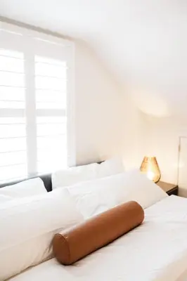 a white bed with a brown pillow on it at Cowry Acres - 11 Acre Enchanted Retreat, Hot Tub in New Hope
