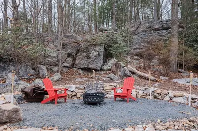 two red chairs sitting next to a fire pit at Cowry Acres - 11 Acre Enchanted Retreat, Hot Tub in New Hope