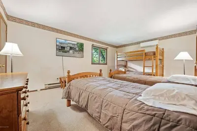 two beds in a room with two bunk beds at Camelback Condo in Tannersville