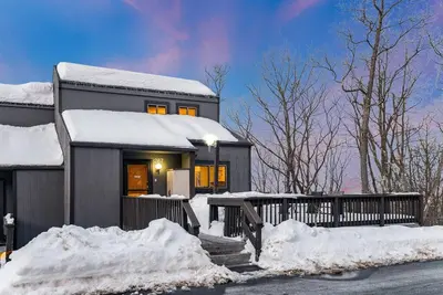 a house covered in snow with snow piled up at Camelback Condo in Tannersville