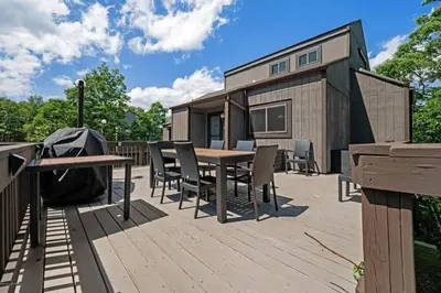 a deck with a table and chairs on a tiny house at Camelback Condo in Tannersville