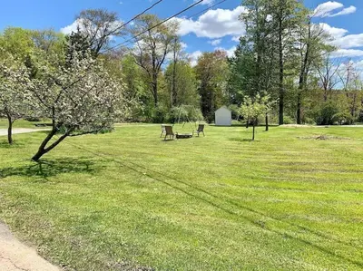 a park with two benches in the grass at Chic Catskills Getaway Bungalow in Hurleyville